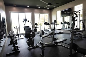 Ein Fitnessstudio mit Laufbändern, Kraftgeräten und Hanteln.