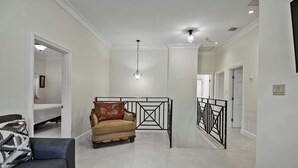 A spacious living area with a sofa, a patterned rug, and a decorative chair. - Comfortable Villa Near Beach + Atlantis + Downtown (Nassau)
