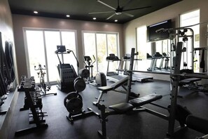 Ein Fitnessstudio mit Laufbändern, Kraftgeräten und Hanteln.