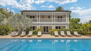 A two-story building with a pool, sun loungers, and tropical plants. - Silk Cotton Studio 2 (Nassau)