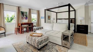 A bedroom with a four-poster bed, a desk, and a chair. - Silk Cotton Studio 3 (Nassau)