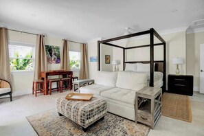 A bedroom with a four-poster bed, a desk, and a chair. - Silk Cotton Studio 3 (Nassau)