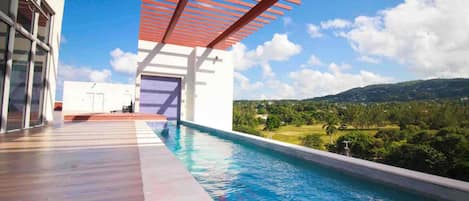 A modern outdoor swimming pool with a clear view of the surrounding landscape.