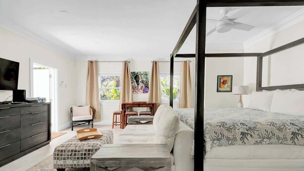 A bedroom with a bed, a desk, a chair, and a television. - 1 BR Studio w/ King Bed + Easy Beach Access (Nassau)