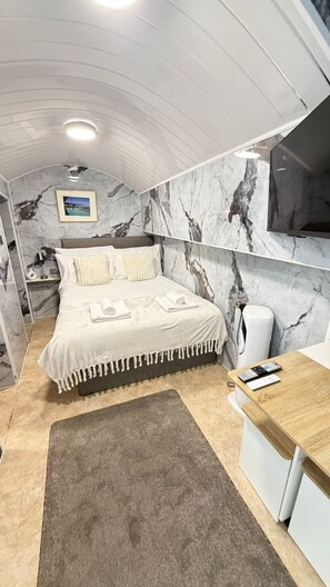 A bedroom with a bed, a desk, and a bathroom. - Cosy London Studio Retreat in the Heart of the City (London)