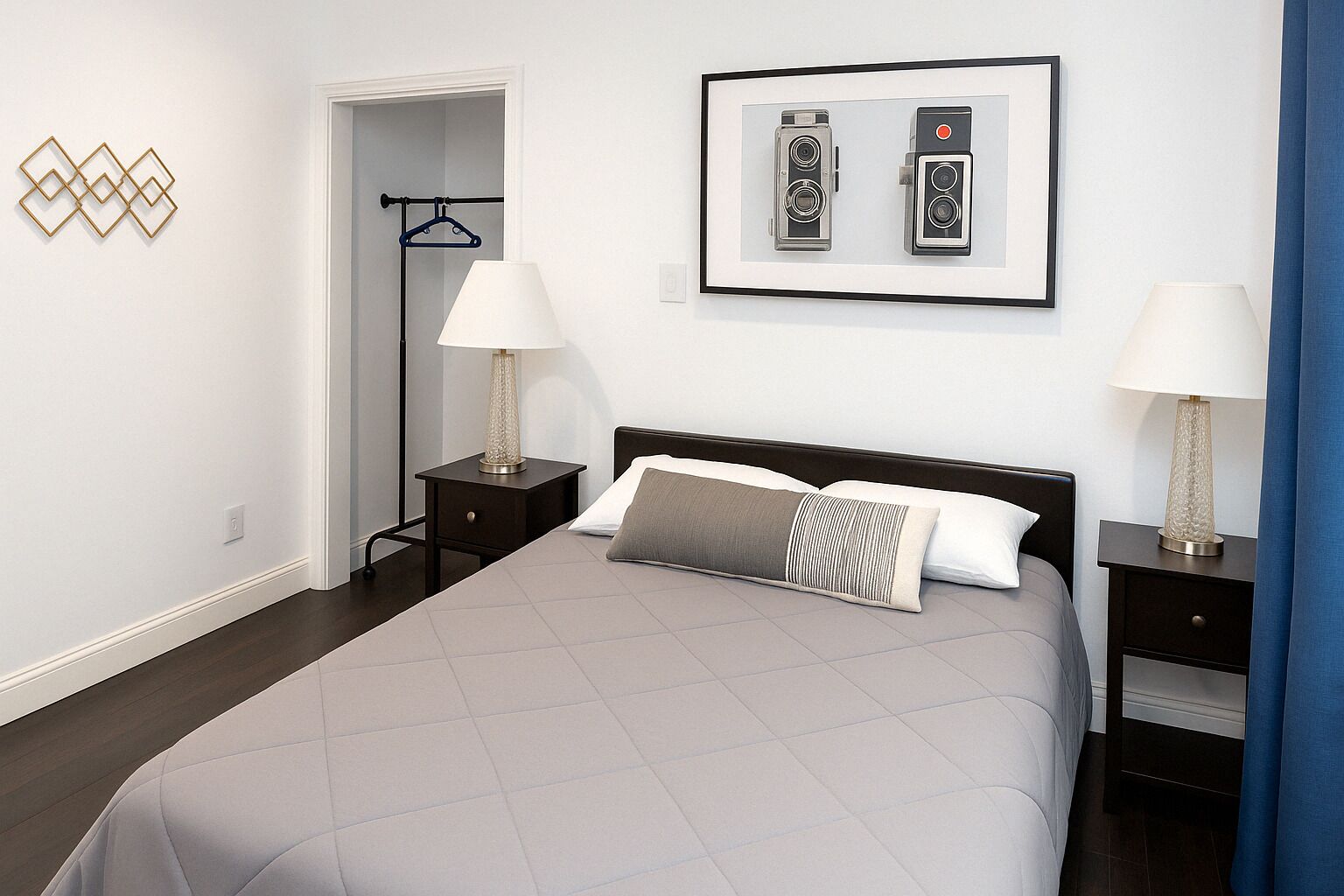 A hotel room with a bed, two bedside tables with lamps, a wardrobe, and a framed picture on the wall.