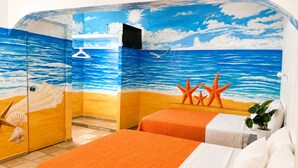 A room with two beds, a beach-themed mural, and a small plant.