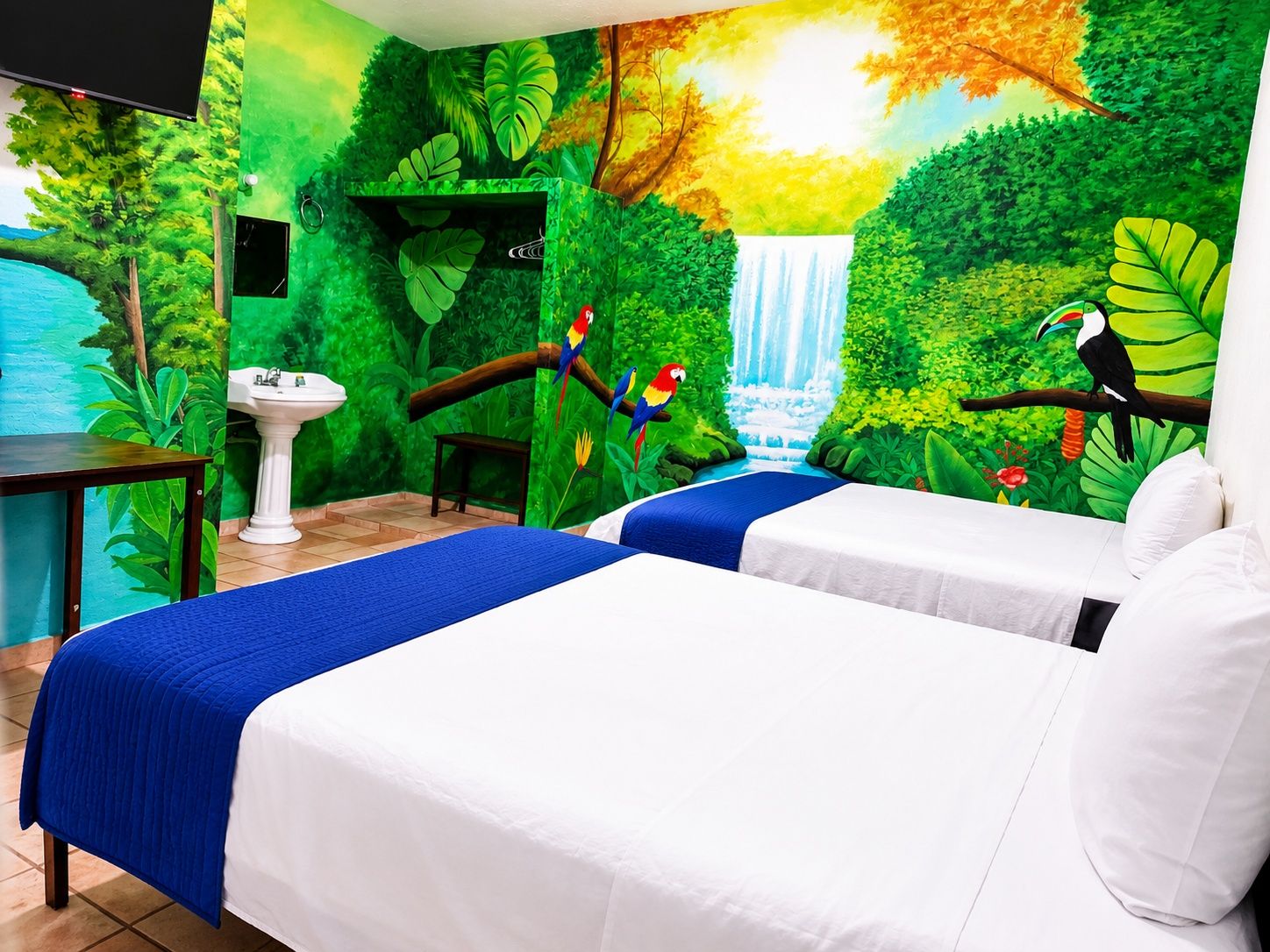 A room with two beds, a sink, and a mural of a waterfall and jungle.