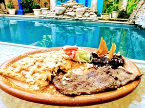 A meal with a pool in the background.