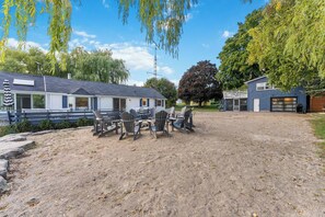 A caravan with a fenced outdoor area, outdoor seating, and a building with a garage. - Private Waterfront Retreat! Sunny Lakehouse + 4 Cottages & 10 King Beds (Prince Edward)