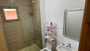 A bathroom with a shower, toilet, sink, and a mirror. - Charming Duplex in enchanting Marrakesh with cool AC (Marrakesh)