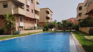A swimming pool surrounded by apartment buildings with balconies. - Charming Duplex in enchanting Marrakesh with cool AC (Marrakesh)