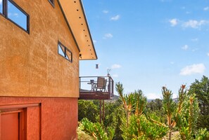 A building with a balcony, a table, and chairs. - New Listing! Vista Bonita | Private 10 Acres | Mountain Views | Shuffleboard (Santa Fe)