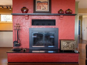 A fireplace with a mantel decorated with vases and a framed picture. - New Listing! Vista Bonita | Private 10 Acres | Mountain Views | Shuffleboard (Santa Fe)