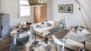 Ein modernes Wohnzimmer mit einer Couch, einem Glastisch und einer großen Stehlampe.