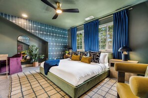 A bedroom with a bed, a desk, a chair, a plant, and a window with curtains. - Gem State Getaway  Game Room+Arcades+Poker+BBQ (Boise)