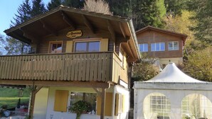 Un chalet doté d’un balcon, une enseigne portant le nom « Annina », et une structure ressemblant à une tente, avec une fenêtre.