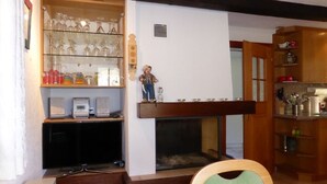 Un salon avec une cheminée, une vitrine et un banc en bois.
