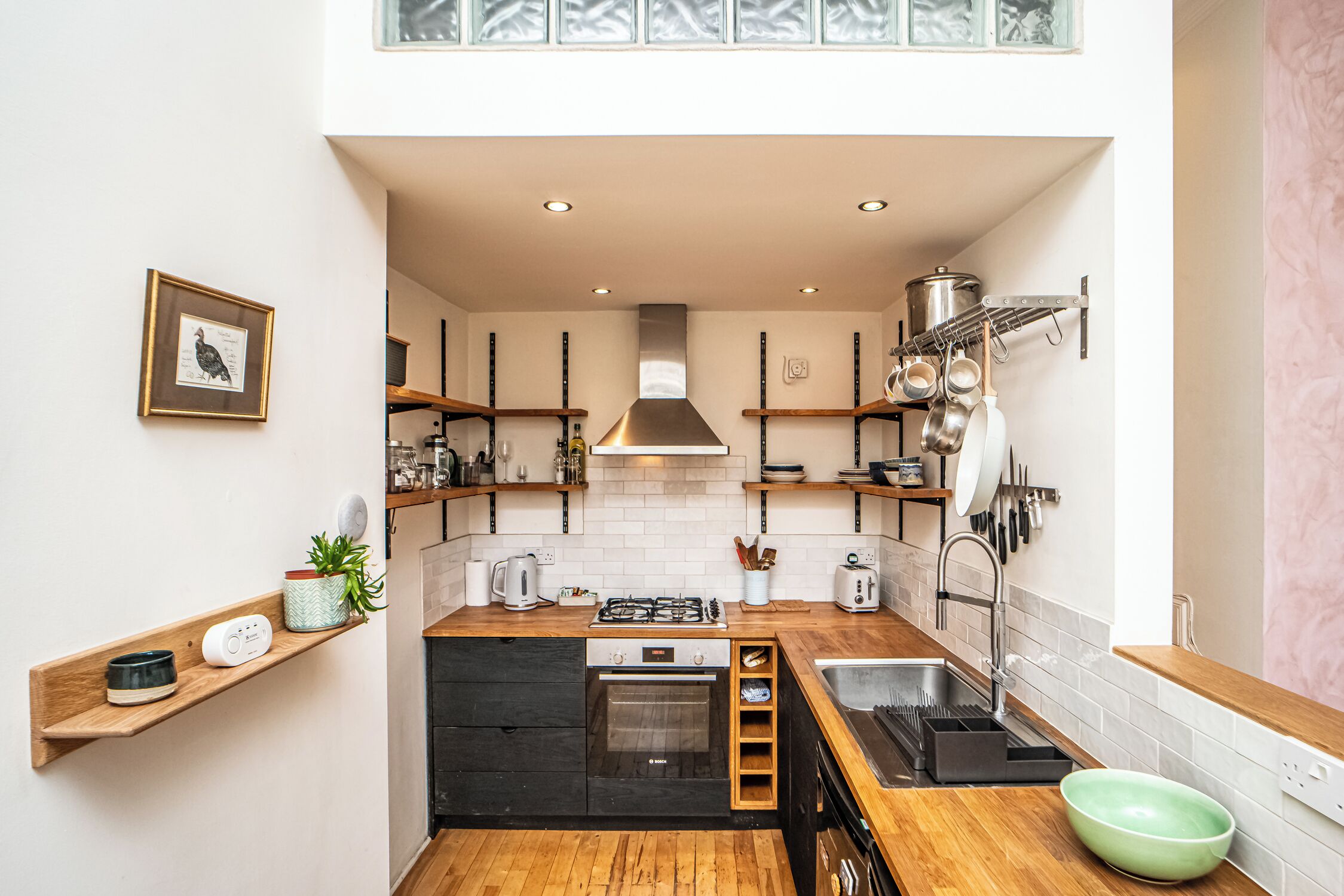 Una cucina compatta con fornello a gas, forno ed elettrodomestici moderni.