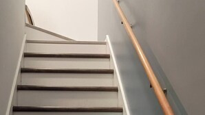 A staircase with wooden steps and a metal handrail.