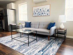 Ein Wohnzimmer mit einer Couch, einem Couchtisch und einem Teppich.