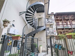 Eine Wendeltreppe mit Metallgeländer, einem Blumentopf und einer Schmetterlingsdekoration.