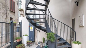 A spiral staircase leading to an upper floor, surrounded by potted plants and a metal gate. - Beautiful apartment for 3 guests with WIFI, A/C, TV and balcony (Colazza)