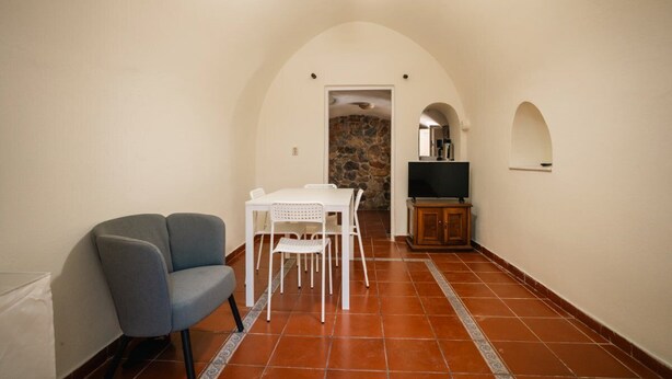 A compact living space with a dining area, a seating area, and a television.