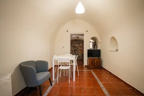 Un espace de vie compact comprenant un coin repas, un coin salon et un téléviseur.