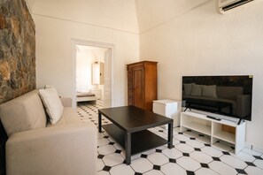 A living room with a sofa, a coffee table, a TV stand, and a cabinet.