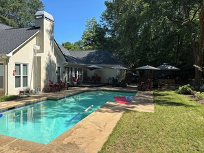A backyard with a swimming pool, outdoor seating, and a covered patio area. - UGA GAME DAY Home w/3 bedrooms-6 People (Athens)