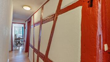 A hallway with exposed wooden beams and a red wall.
