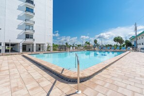A rectangular swimming pool with a tiled edge, surrounded by a paved deck. - 🏖️Beachfront, Pool and Stunning Sunsets | Sunset Condo 502🌅 (Fort Myers Beach)