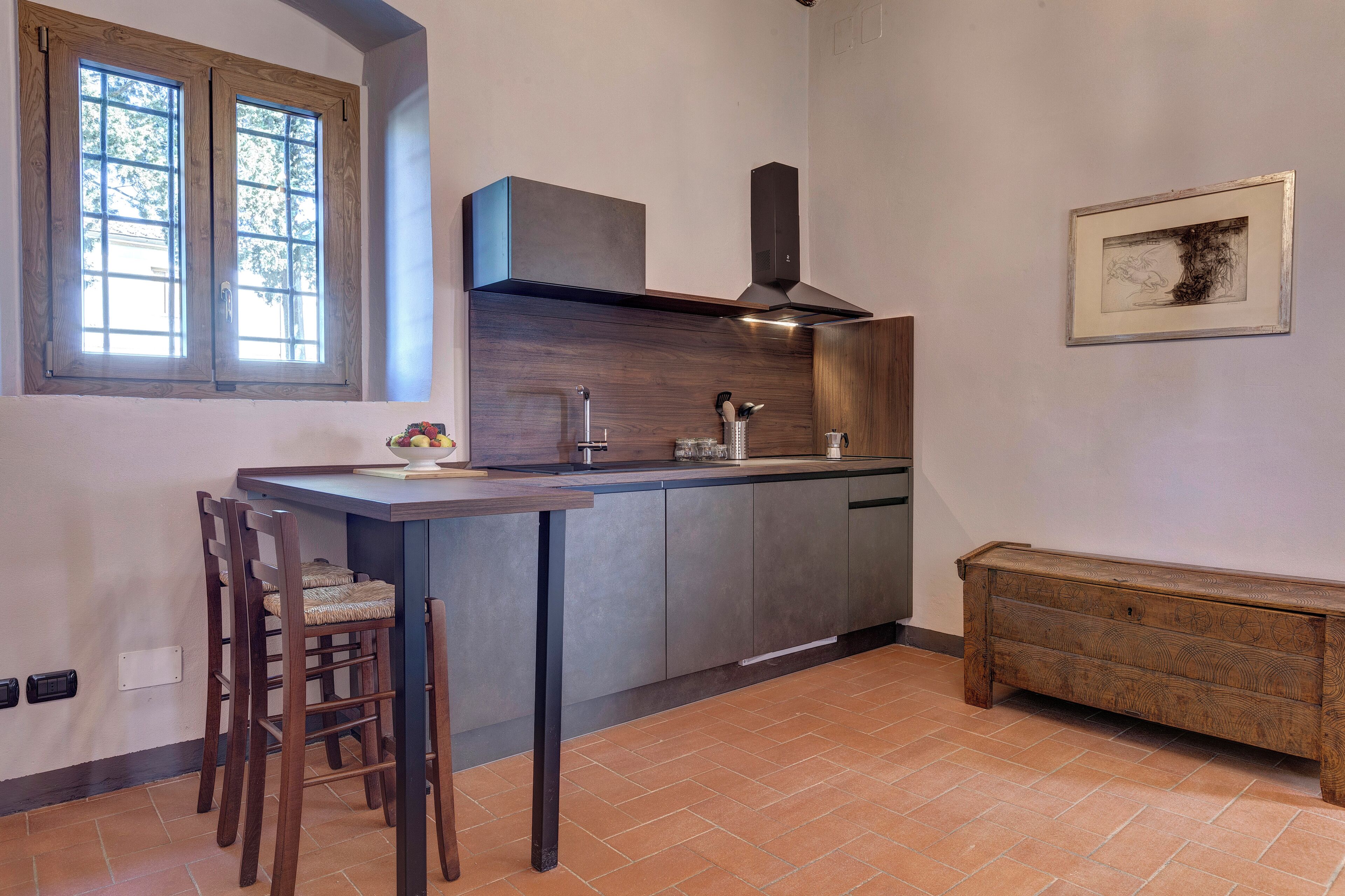 Una cucina compatta con isola integrata, una finestra e una panca.
