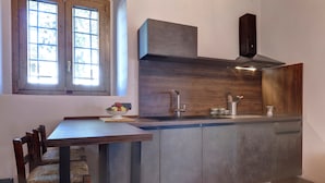 Una cucina con un armadietto in legno, un piano cottura integrato e una finestra.