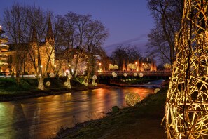 Un río con decoraciones iluminadas y un puente.