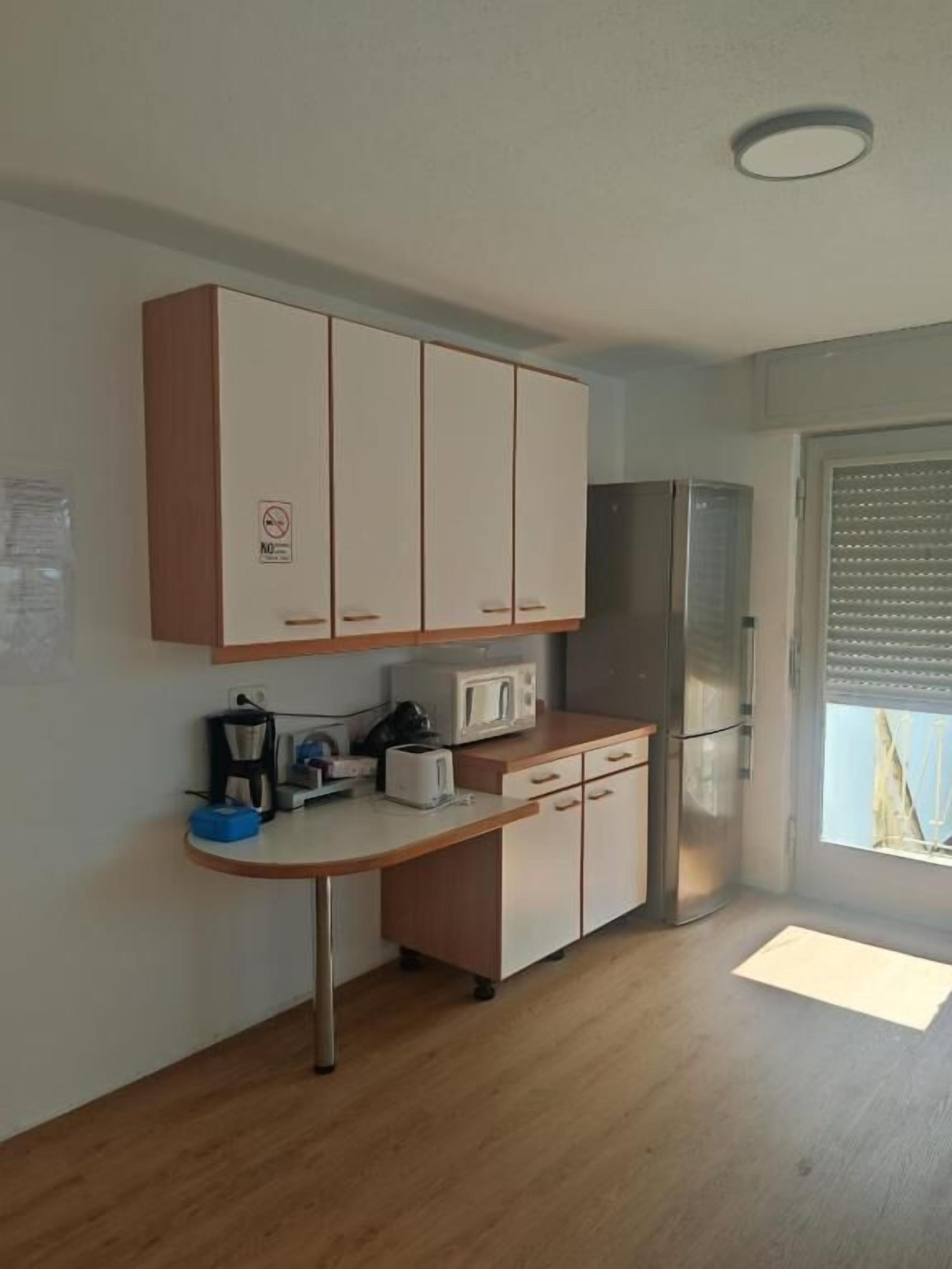 A compact kitchen with a microwave, toaster, and refrigerator.
