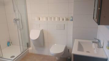 Ein Badezimmer mit Duschkabine, Toilette und Waschbecken.
