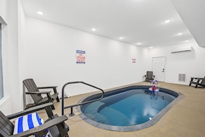 Ein Hallenbad mit Rettungsschwimmer-Schild, einer Tür und einer Bank.