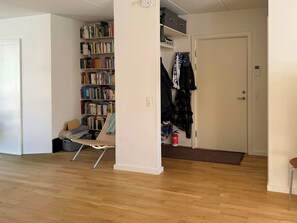 Ein Zimmer mit Holzboden, einem Bücherregal, einer Tür und einem Garderobenschrank.