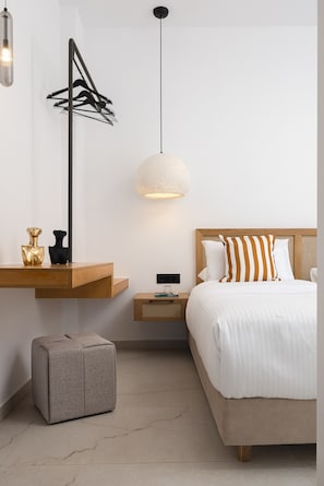 A modern bedroom with a bed, bedside table, nightstand, and a hanging light fixture. - Luxurious Villa Poseidon - With Private Pool (Bali)