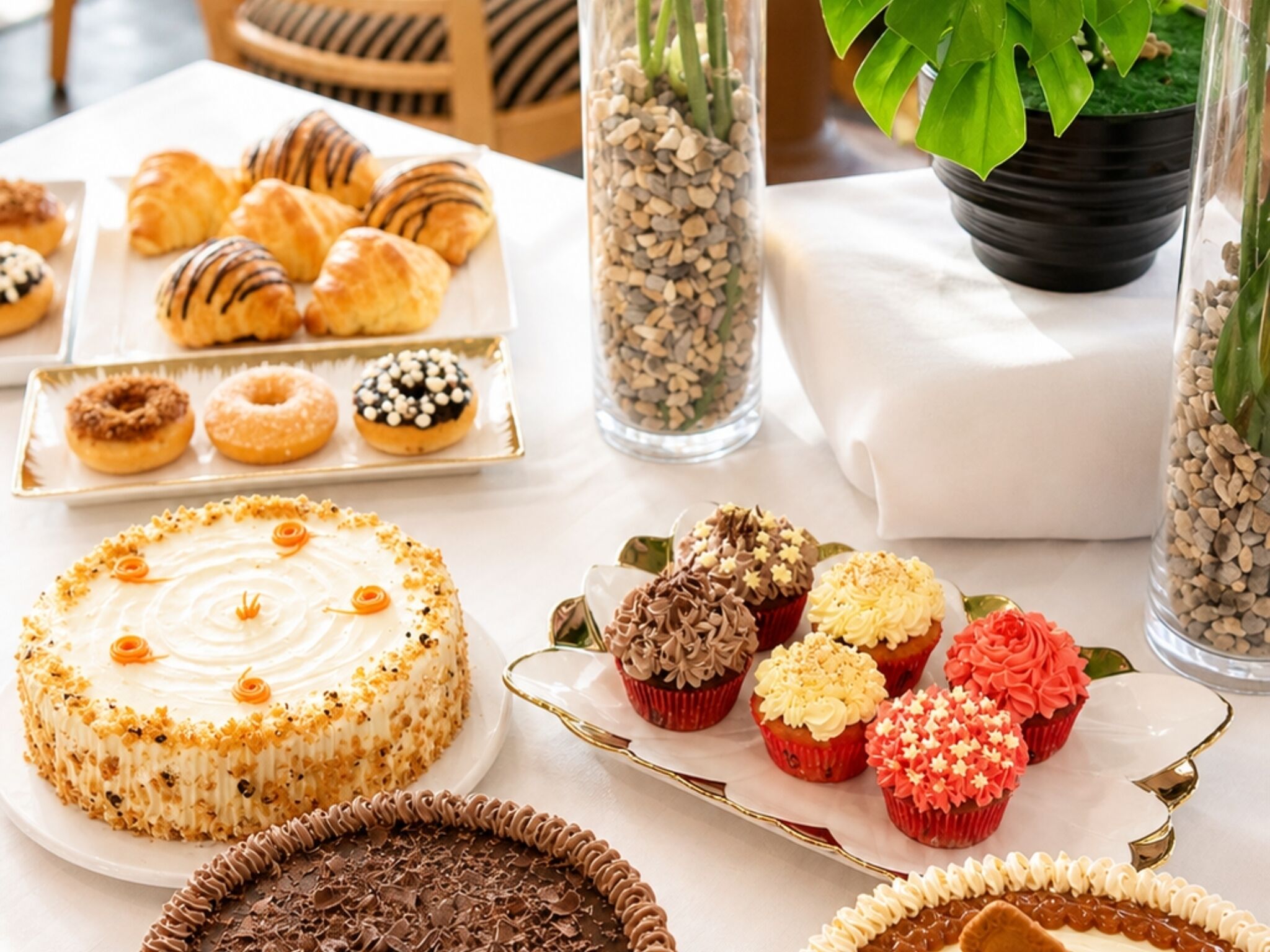 Variedad de postres en una mesa, incluyendo pastel, cupcakes y pastelería.