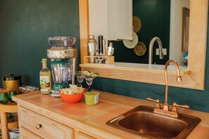 A kitchen with a sink, a blender, a bottle of lime, a bowl of chips, and a bottle of sauce. - Greenville Riverfront Escape w/ Hot Tub, Game Room, Sauna & River Access! (Greenville)