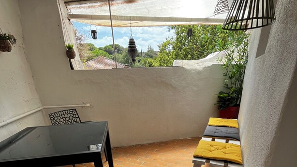 A patio area with a table and chairs, a small bench, and a potted plant. - A house in the heart of the village of Mourèze, just a stone's throw from the Cirque. (Mourèze)