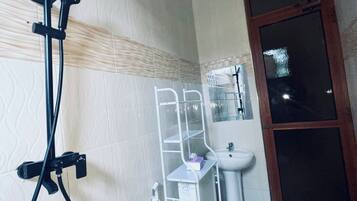 Chuveiro, toalhas de banho, sabonete, papel higiênico