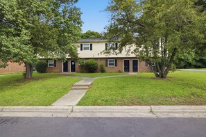 A two-story house with a front yard, a sidewalk leading to the front door, and a street in front. - Durham Home Near Duke-Fast WiFi & Self Check-In (Durham)