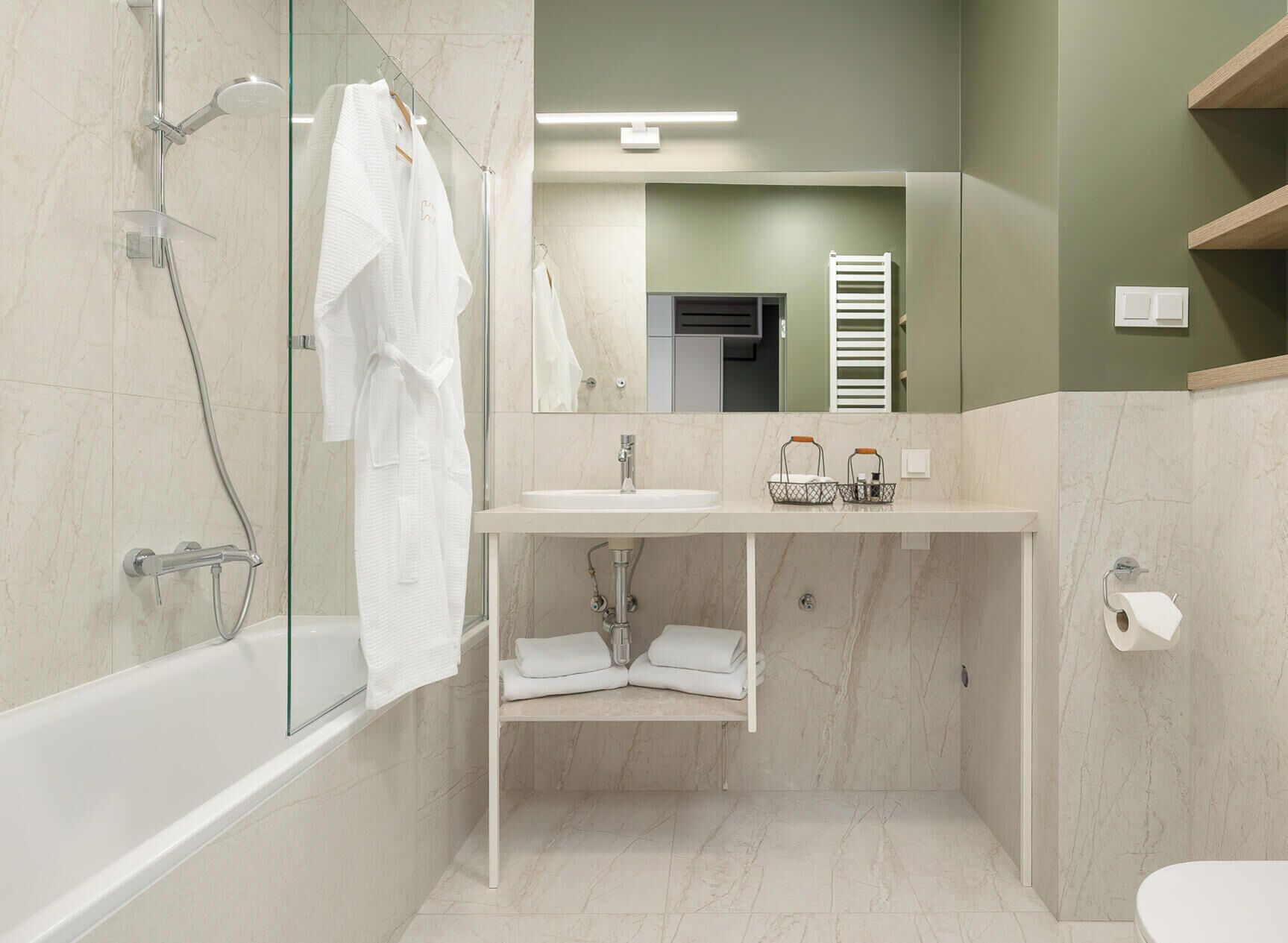 A modern bathroom with a glass-enclosed shower, a white sink, and a toilet.