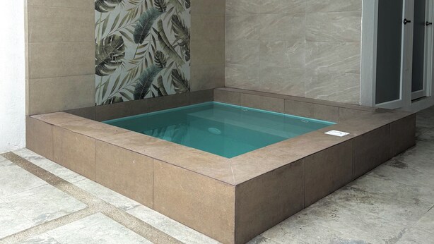 A rectangular hot tub with a tiled border, surrounded by walls with a leaf pattern and a plain tiled wall. - Azul Paradise in San Clemente, Ecuador (San Clemente)