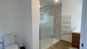 Een douche, handdoeken, zeep, toiletpapier
