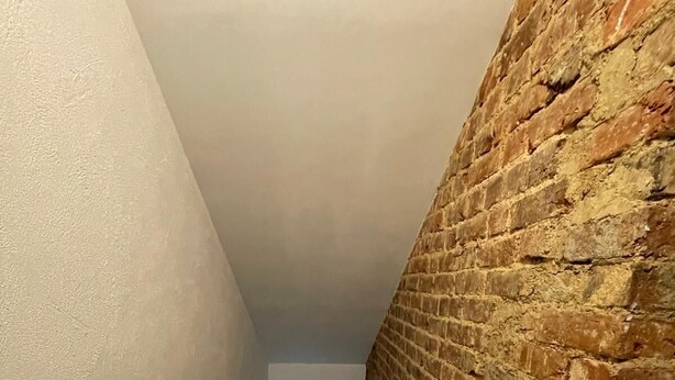 A staircase with a brick wall on one side and a plain wall on the other, leading to an upper floor. - Newly built holiday cottage in a mill by the Loir River (Marboué)